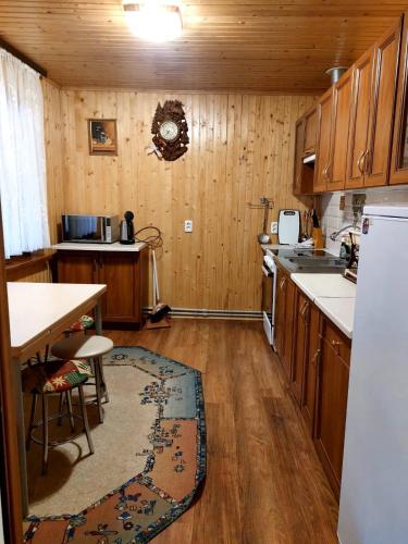 a kitchen with wooden cabinets and a table and a sink at Сімейний котедж У Діани in Tatariv