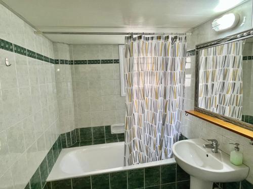 ein Badezimmer mit einem Waschbecken, einer Badewanne und einem Waschbecken in der Unterkunft Two Bedroom City Seaside Apartment in Limassol