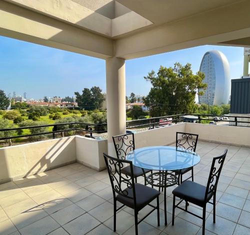 a patio with a table and chairs on a balcony at Two Bedroom City Seaside Apartment in Limassol