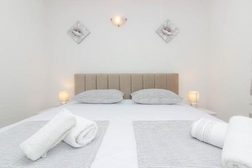 1 dormitorio con 1 cama con toallas en Apartmani Dada en Biograd na Moru