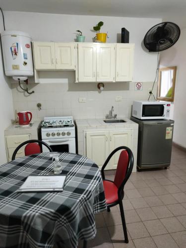 cocina con mesa, sillas y fregadero en Departamento céntrico en Posadas D6 garage opcional en Posadas