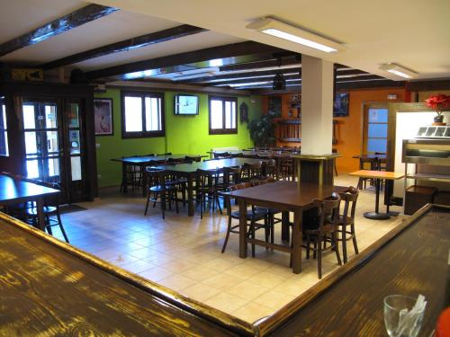 a restaurant with tables and chairs and green walls at Alberg Les Daines in Espot