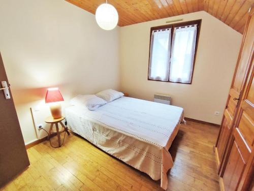 a bedroom with a white bed and a window at Le chant de la Pique, maison T4, jardin, parking gratuit, wifi, 6 personnes in Luchon