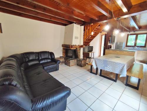 un salon avec un canapé en cuir et une table dans l'établissement Le chant de la Pique, maison T4, jardin, parking gratuit, wifi, 6 personnes, à Luchon