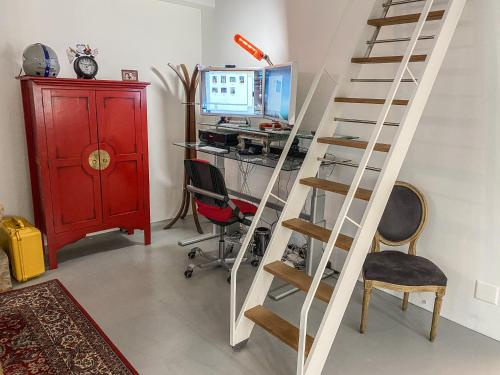 a ladder in a room with a desk and a computer at Loft Designer in Neuhausen am Rheinfall