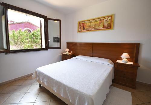 a bedroom with a white bed and a window at Hotel Il Girasole in Villasimius