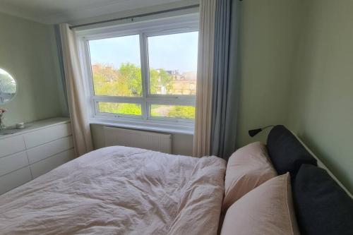 a bedroom with a bed in front of a window at Bright & Lovely & apartment in Whetstone