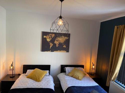 two beds in a room with a map on the wall at Luxury accommodation. in Wallasey