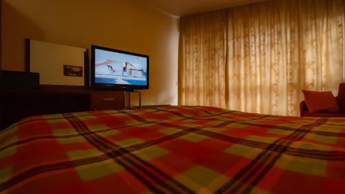 a bedroom with a bed and a flat screen tv at Pirin Place Bansko in Bansko