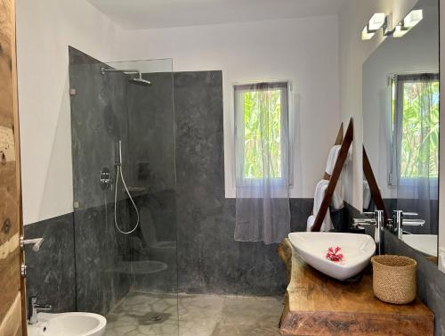 a bathroom with a shower and a sink and a toilet at Tangawizi Villa with Private Pool ZanzibarHouses in Kiwengwa