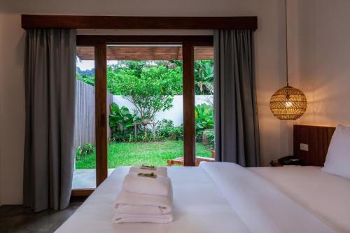 - une chambre avec un lit et une grande fenêtre dans l'établissement Phang Nga Origin Hotel, à Phangnga
