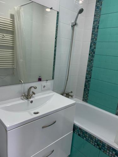 ein Badezimmer mit einem Waschbecken, einem Spiegel und einer Badewanne in der Unterkunft Квартира с отдельным входом с улицы in Chişinău