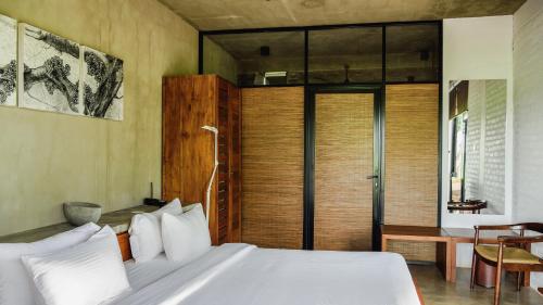 a bedroom with a bed and a sliding glass door at Kalundewa Retreat in Dambulla