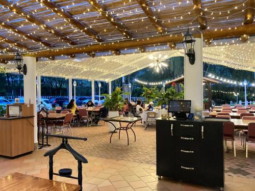 un restaurante con mesas y sillas y personas sentadas en mesas en Bombon spa destination, en Villa de Leyva