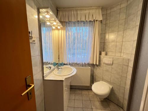 a bathroom with a sink and a toilet and a window at Buhne IV OG in Wieck