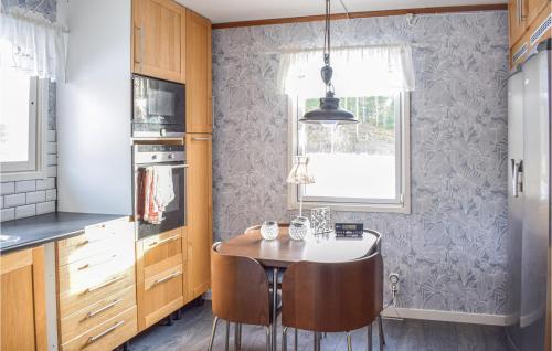 eine Küche mit einem Tisch und Stühlen im Zimmer in der Unterkunft 2 Bedroom Amazing Home In Figeholm in Figeholm