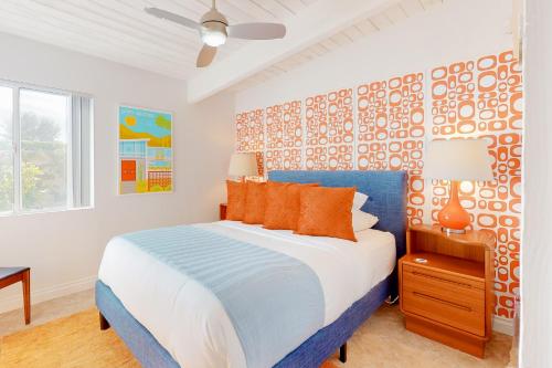 a bedroom with a blue and white bed with orange pillows at Desert Willow Mod Permit# 5268 in Palm Springs