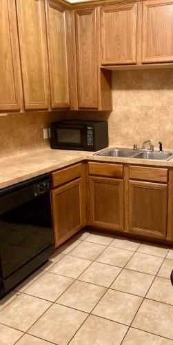 a kitchen with wooden cabinets and a sink and a microwave at Lovely Downtown Room #2 no smoking no kids second floor in Houston