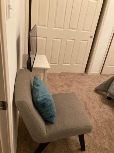 a room with a chair with a pillow and a television at Lovely Downtown Room #2 no smoking no kids second floor in Houston