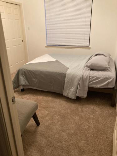a bed in a bedroom with a window and a chair at Affordable Central Houston Stay Minutes from Downtown No Smoking in Houston