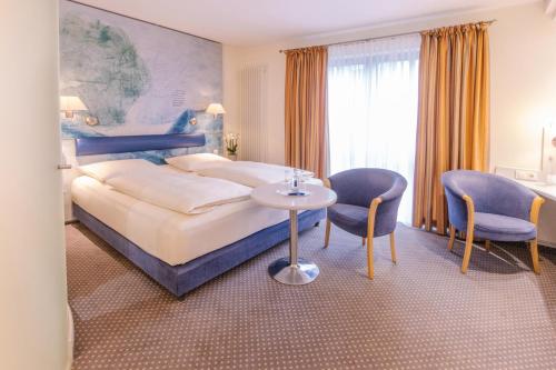 a hotel room with a bed and a table and chairs at Romantik Hotel Gasthaus Rottner in Nuremberg