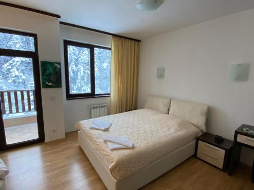 a bedroom with a bed with two towels on it at Charming Winter Studio in Borovets