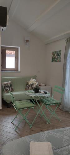 a living room with a couch and a table and chairs at Duomo Rooms Cefalù in Cefalù