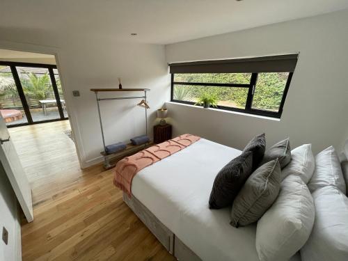 a bedroom with a bed with pillows and a window at River guest house with jacuzzi fire and boat hire in Staines