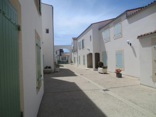 an empty alley between two white buildings at Charmant Studio à proximité du Port de St Martin de Ré in Saint-Martin-de-Ré