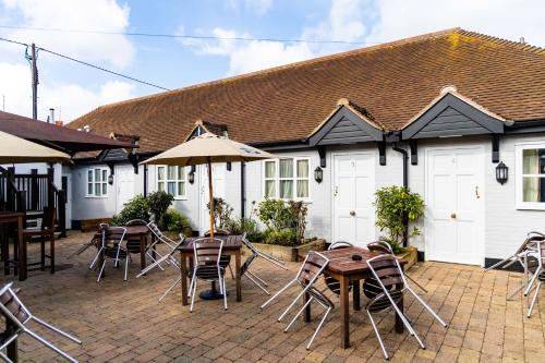 un patio con mesas y sillas y un edificio en The Cherry Tree en Abingdon