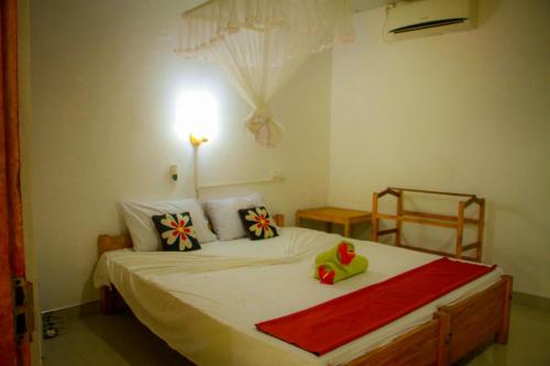 a bedroom with a large white bed with pillows at Travelodge Sigiriya in Sigiriya