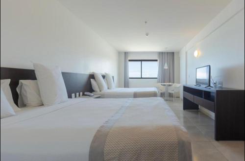 馬塞約的住宿－Flat novo à Beira-mar，大型酒店客房设有一张大床和一张沙发。