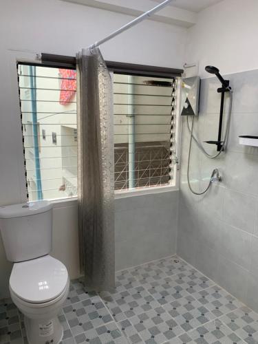 a bathroom with a toilet and a shower at Barzilla Bar And Guesthouse in Pattaya