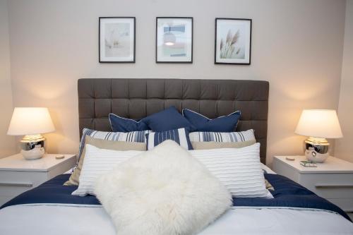 un letto con cuscini blu e bianchi e 2 lampade di Gorgeous Two Bedroom Apto Close to Disney 306 a Kissimmee