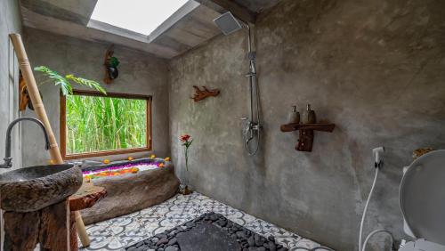 a bathroom with a tub and a sink and a window at Iyume Villas in Tegalalang