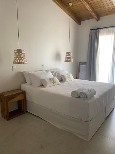 a bedroom with a large white bed with two pendant lights at Hotel Boutique Miss Olivos in San Rafael