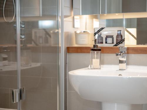 ein Bad mit einem Waschbecken und einer Glasdusche in der Unterkunft Apartment 17 Air-conditioned Bedrooms in Torquay