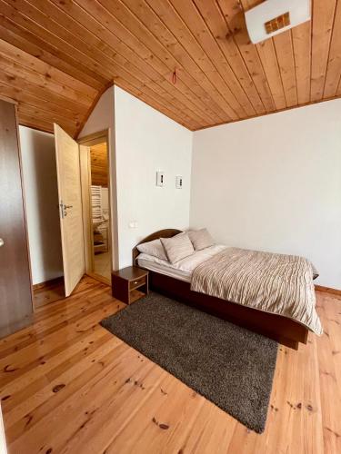 a bedroom with a bed and a wooden ceiling at Ošupynė in Šventoji