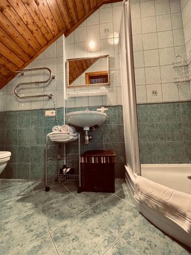 a bathroom with a sink and a mirror and a tub at Ošupynė in Šventoji