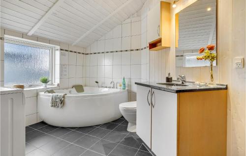 a bathroom with a tub and a toilet and a sink at Nice Home In Haderslev With 3 Bedrooms, Sauna And Wifi in Råde