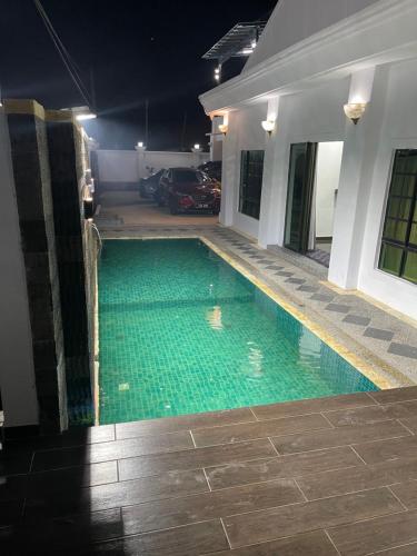 a swimming pool in the middle of a house at night at Aainaa Villa Homestay in Pasir Mas