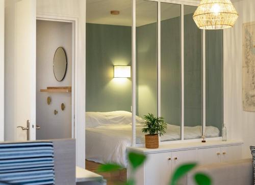 ein Schlafzimmer mit einem Spiegel und einem Bett darin in der Unterkunft Appartement vue sur mer, 100 m de la plage in Carantec