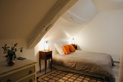 a bedroom with a bed with orange pillows on it at Maison Céleste in Nuits-Saint-Georges