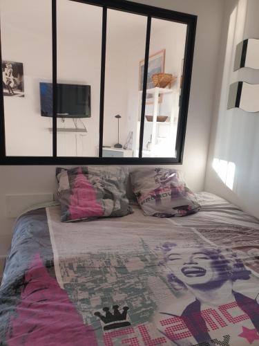 une chambre avec un lit avec une grande fenêtre dans l'établissement T2 vue mer avec parking privé, à Saint Pierre La Mer