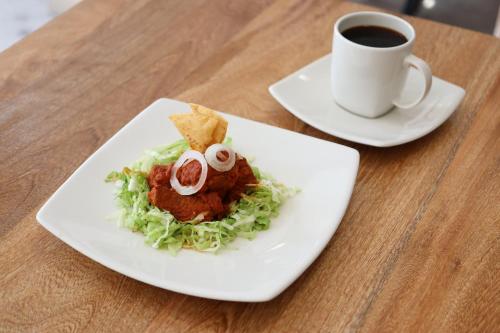 une assiette de nourriture et une tasse de café sur une table dans l'établissement HOTEL CHURUMUCO, à San José Iturbide