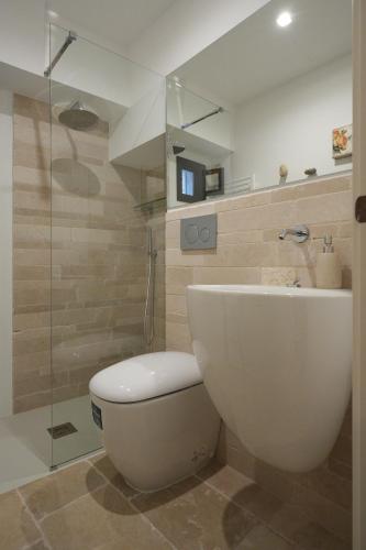 a bathroom with a toilet and a glass shower at AMIN - centro storico - appartamento in Polignano a Mare