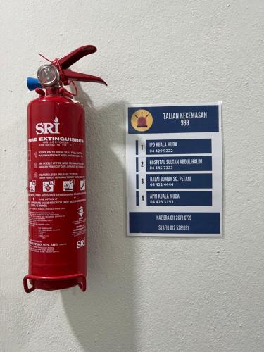 a fire extinguishment sign hanging on a wall at Ali Homestay Sungai Petani in Sungai Petani