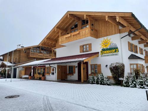 a building with a sign on it in the snow at Sonnhof's Ferienresidenz in Reit im Winkl