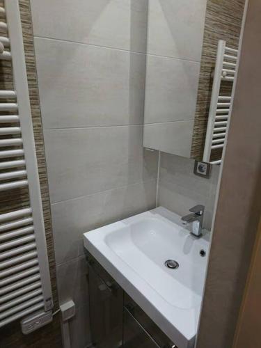 une salle de bain avec un lavabo blanc et un miroir dans l'établissement Le Diamant 1 App R 12, à Les Deux Alpes