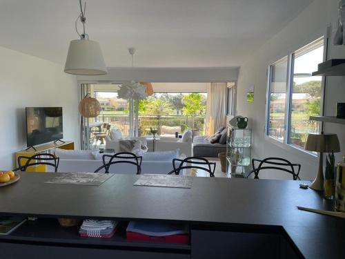une cuisine et un salon avec une table et des chaises dans l'établissement Horizon Golf - Luxueux Appart vue piscine et golf - Wifi - Parking, à Saint-Cyprien